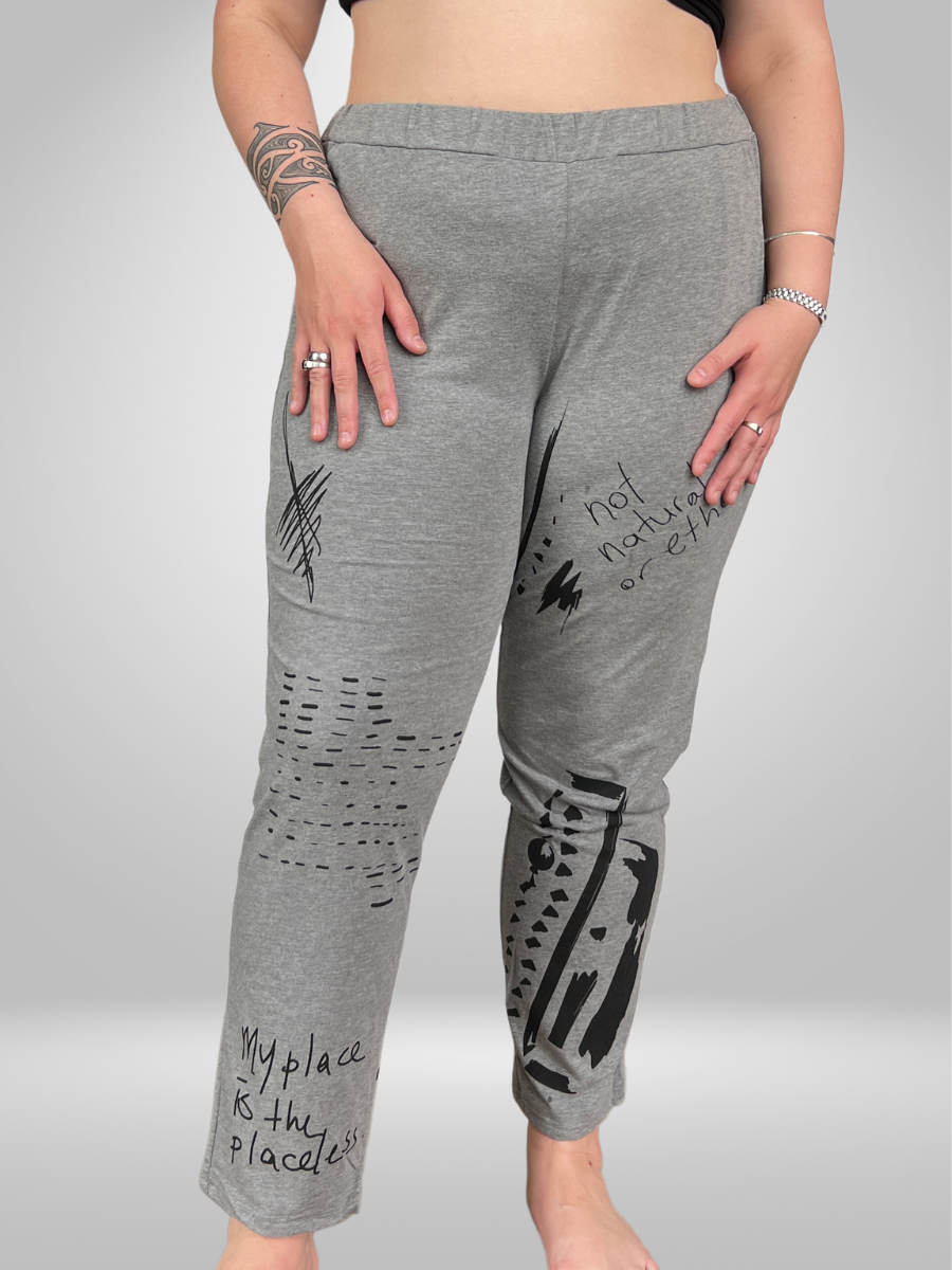 Grey joggers with an abstract black print, styled for plus-size women (sizes 18-24). Features include cuffed hems and an elastic waistband for comfort.